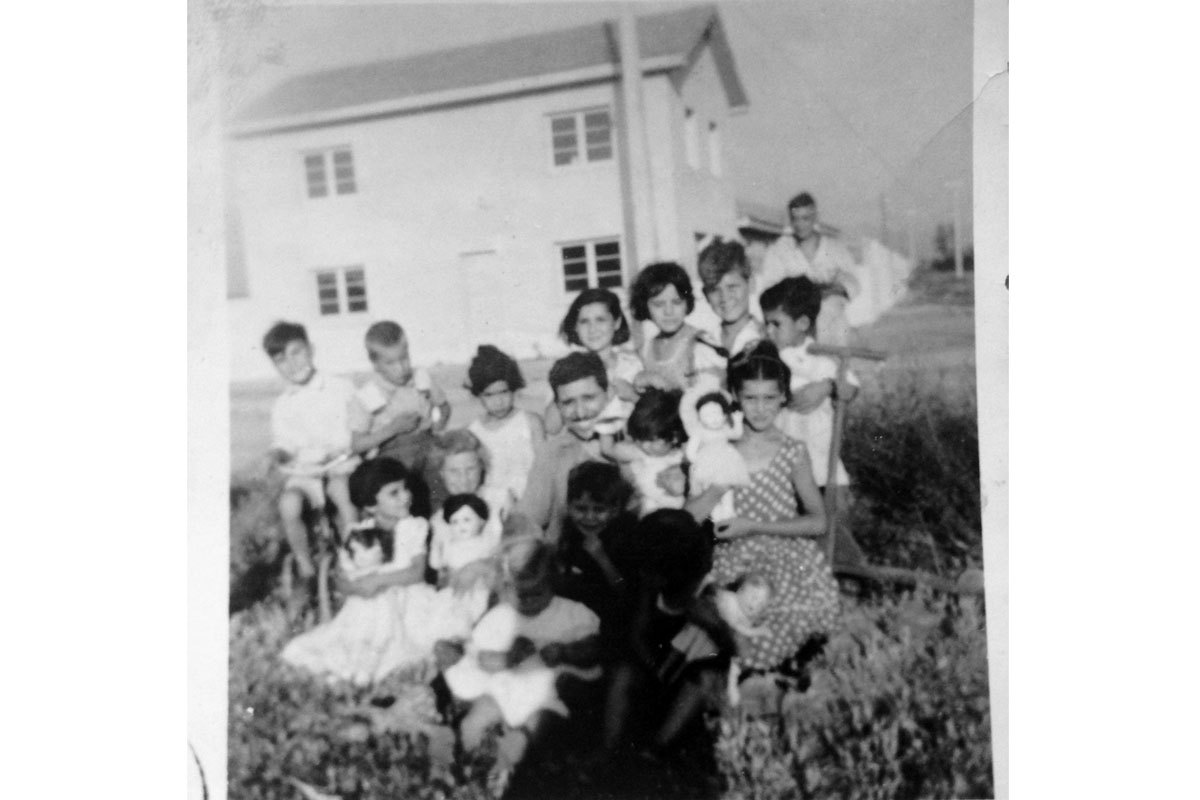 Manuel junto a sus hijos mayores: Irma, Leo y Patricia, junto a pequeños vecinos en un cumpleaños, alrededor de 1956. Población El Carmen, Santiago.