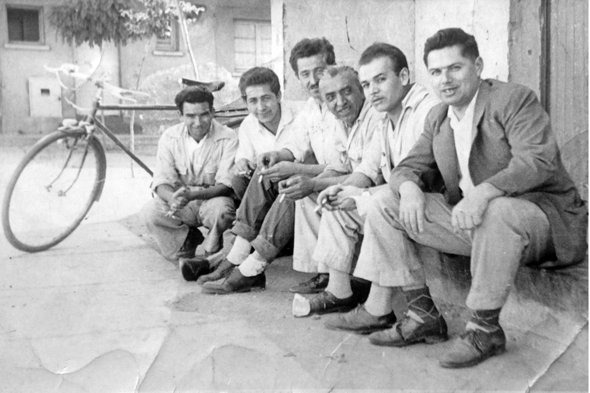 Manuel con sus amigos del trabajo de Industrias Hirmas, sentados fuera de la lavandería de la población. Manuel es el tercero de izq. a derecha. Santiago, alrededor de 1970.